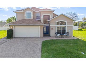 Charming two-story home boasts a manicured lawn and brick driveway with a two car garage at 7902 Silver Bass Ct, Kissimmee, FL 34747