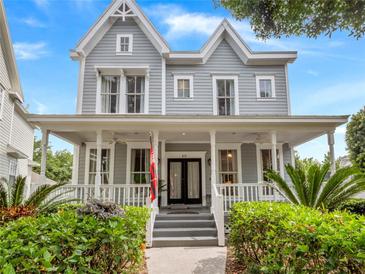 Charming two-story home with a welcoming front porch and neatly landscaped front yard at 819 Veranda Pl, Celebration, FL 34747