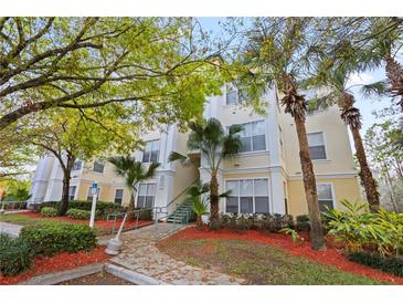 Inviting condo building with lush landscaping, mature trees, and accessible entry features at 8929 Legacy Ct # 106, Kissimmee, FL 34747