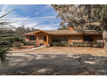 Charming single-story brick home with a well-manicured front yard and a cozy, inviting entrance at 1101 N Valencia Ave, Howey In The Hills, FL 34737