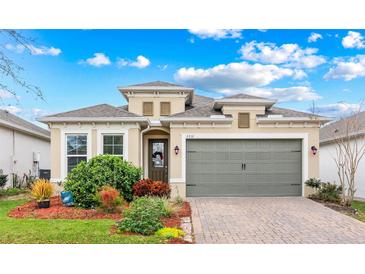 Charming home with a well-manicured lawn and a brick driveway leading to a two-car garage at 2212 Antilles Club Dr, Kissimmee, FL 34747