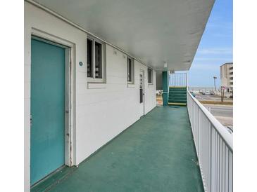 Bright condo hallway view with green carpet, a blue door, and ocean views at 2727 N Atlantic Ave # 2020, Daytona Beach, FL 32118