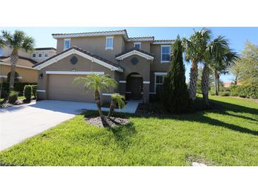 Charming two-story home featuring a lush green lawn, well-maintained landscaping, and a two-car garage at 5384 Oakbourne Ave, Davenport, FL 33837