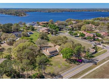 Stunning aerial view of a two-story home on a large lot near a beautiful lake at 9332 Windy Ridge Rd, Windermere, FL 34786