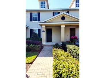 Charming townhome entrance with a well-maintained front yard, brick pathway, and inviting front door at 14448 Pleach St, Winter Garden, FL 34787
