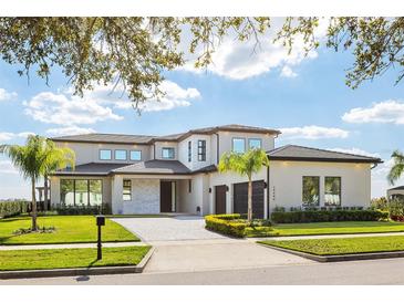 Stunning two-story home with a paved driveway, lush landscaping, and a modern design at 14544 Avenue Of The Rushes, Winter Garden, FL 34787