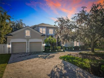 Stunning exterior view of home featuring a three-car garage and meticulously landscaped front yard with paver driveway at 254 Sylvan Blvd, Winter Park, FL 32789