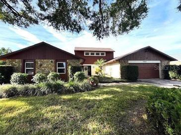 Charming home with stone accents, lush landscaping, and a well-maintained front yard at 5220 Jade Cir, Orlando, FL 32812