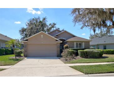 Charming home featuring a manicured lawn, mature landscaping, and a two-car garage at 781 Lakeworth Cir, Lake Mary, FL 32746
