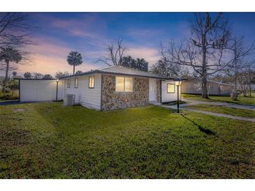 A lovely exterior view of the home and its large lawn, with exterior stone accents at 1203 S Pomegranite Ave, Sanford, FL 32771