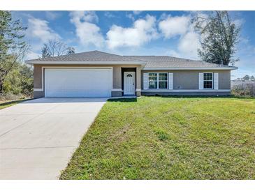 Charming single-story home featuring a two-car garage and well-manicured front lawn at 16121 Sw 24Th Court Rd, Ocala, FL 34473