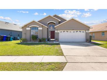 Charming single-story home featuring a well-manicured lawn and a two-car garage at 2422 Black Powder Ln, Kissimmee, FL 34743