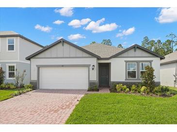 Charming single-Gathering home with a brick driveway, a well-manicured lawn, and stylish exterior paint at 360 Birkdale Dr, Daytona Beach, FL 32124