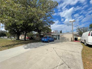 Charming single-story home with a well-maintained lawn, and a blue sedan in the driveway at 4007 Clarcona Ocoee Rd, Orlando, FL 32810