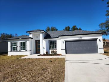 Charming single-story home with a gray roof, a two-car garage, and a well-manicured front yard at 2693 Sw 153Rd Place Rd, Ocala, FL 34473