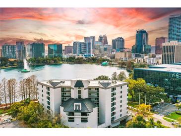 Striking aerial view of the condo building overlooking a picturesque lake and the vibrant downtown skyline at 401 E Robinson St # 101, Orlando, FL 32801