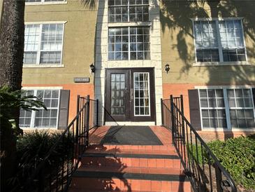 Building with brown double doors and brick steps leading up to entrance and iron railings at 4154 Versailles Dr # 4154D, Orlando, FL 32808
