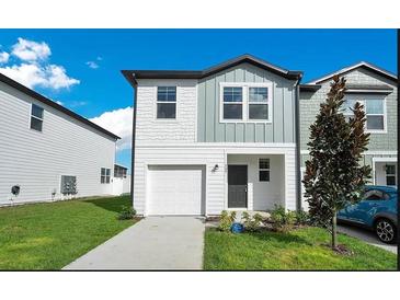 Charming two-story home featuring a one-car garage, manicured lawn, and well-maintained landscaping at 509 Madison Dr, Davenport, FL 33837