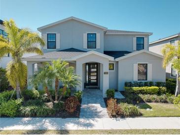 Beautiful two-story home with a lush landscaped yard and welcoming front porch at 7464 Gathering Dr, Reunion, FL 34747