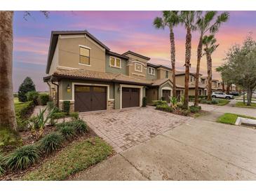 Townhome exterior featuring a brick driveway and a two-car garage at 8924 Azalea Sands Ln # 8924, Davenport, FL 33896