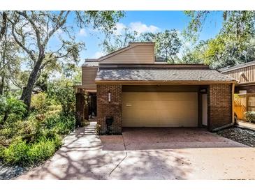 Charming home with a brick facade, covered parking, and lush landscaping at 111 Autumn Dr, Longwood, FL 32779