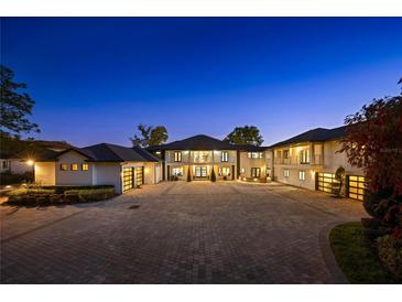 Magnificent two-story home with a vast driveway, garages, manicured landscaping, and elegant architecture at 3120 Downs Cove Rd, Windermere, FL 34786