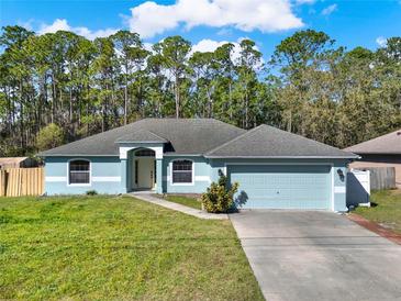 Charming single-story home with a well-manicured lawn and an attached two-car garage in a quiet neighborhood at 3200 Utah Dr, Deltona, FL 32738