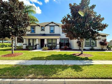 Charming two-story home featuring manicured landscaping, lush green lawn, and welcoming curb appeal at 4113 Golden Willow Cir, Apopka, FL 32712