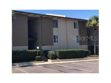 A well-maintained condo building with manicured shrubs and an expansive parking area at 592 Orange Dr # 140, Altamonte Springs, FL 32701