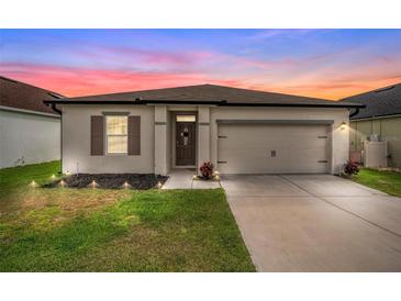 Charming single-story home featuring a well-maintained lawn and a two-car garage with pleasant exterior paint at 650 Peyton Brooke Way, Winter Haven, FL 33881