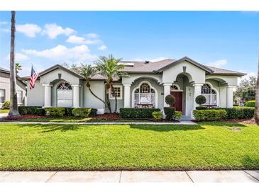 Inviting single-story home with manicured lawn, arched windows, and stately columns at 739 Spring Island Way, Orlando, FL 32828