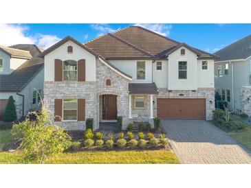 Beautiful two-story home featuring a stone facade, brown shutters, and a well-manicured front yard at 11464 Beau Repost Dr, Orlando, FL 32832