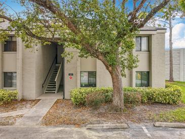 Inviting condo exterior with stairway access, lush landscaping, and assigned parking at 163 Springwood Cir # D, Longwood, FL 32750