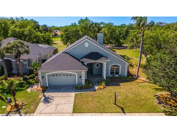 Charming single-Gathering home featuring a well-manicured lawn, lush landscaping, and an attached two-car garage at 1714 Golfview Dr, Kissimmee, FL 34746