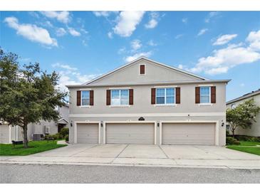 Three car garage townhome with neutral siding, brown shutters, and well-maintained landscaping at 3528 Seneca Club Loop # 103 - C, Orlando, FL 32808