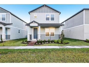 Charming two-story home with gray siding, landscaped yard and cozy front porch at 4673 Cross Prairie Pkwy, St Cloud, FL 34772