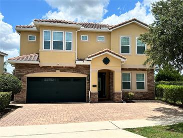Stunning two-story home featuring a tile roof, brick accents, and manicured landscaping at 7668 Wilmington Loop, Kissimmee, FL 34747
