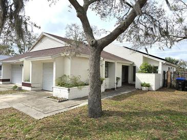 Charming home featuring a well-maintained lawn, attached garage, and inviting curb appeal at 2452 Atrium Cir, Orlando, FL 32808