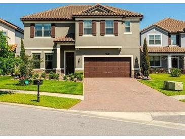 Charming two-story home with a brown two car garage, shutters, and a well manicured front yard at 281 Ancona Ave, Debary, FL 32713