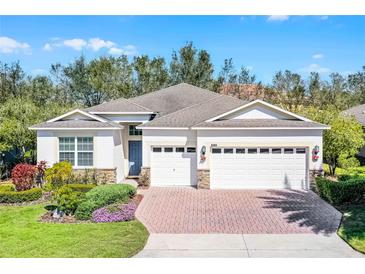 Charming single Gathering home featuring a 3-car garage, brick-paved driveway, and meticulously manicured landscaping at 3618 Solana Cir, Clermont, FL 34711