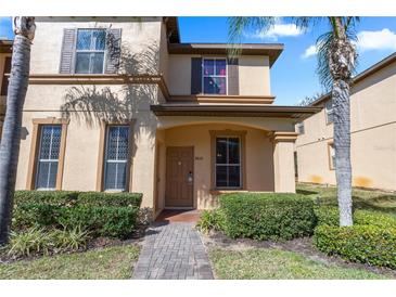 Inviting two-story home with a neatly landscaped front yard and brick walkway to the front door at 3653 Calabria Ave, Davenport, FL 33897