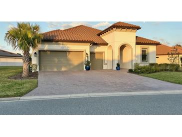 Stunning single-story home with a barrel tile roof, paver driveway, and attached two-car garage at 3704 Via Monte Napoleone Dr, Poinciana, FL 34759