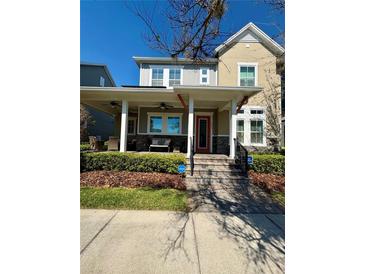 Charming two-story home with inviting front porch and manicured landscaping at 7873 Dausset St, Orlando, FL 32827