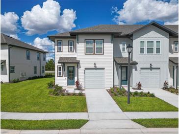 Charming two-story townhome with lush lawn, one-car garage, and inviting curb appeal at 929 Conch Rd, Davenport, FL 33896