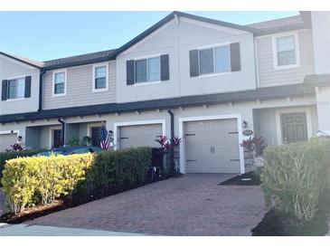 Charming townhome with attached garage, stone accents, and lush landscaping at 1013 Flowing Tide Dr, Orlando, FL 32828