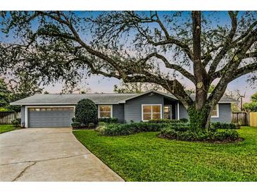 Charming single-story home with a lush, mature tree in a well-maintained front yard at 112 E Cumberland Cir, Longwood, FL 32779