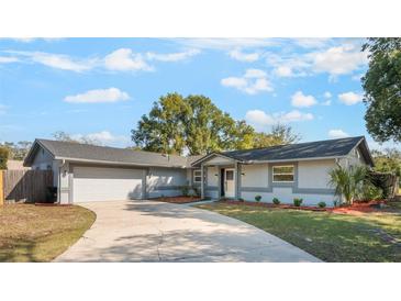 Charming single-story home showcasing a well-manicured lawn and a spacious two-car garage at 172 Post And Rail Rd, Longwood, FL 32750