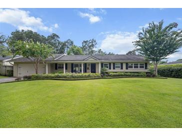 Charming single-story home with a well-manicured lawn and mature landscaping at 1771 Winchester Dr, Winter Park, FL 32789