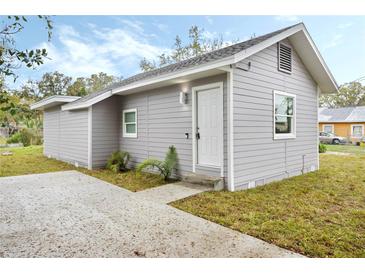 Charming gray home with a well-maintained lawn and a concrete walkway leading to the front door at 230 Hennis Rd, Winter Garden, FL 34787