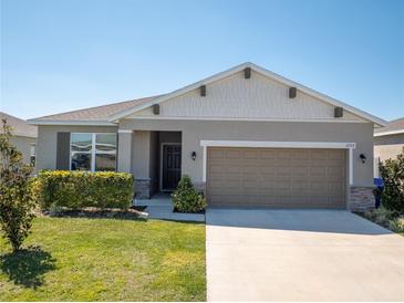 Charming single-story home with a well-manicured lawn and a two-car garage at 2715 Rowan St, Tavares, FL 32778